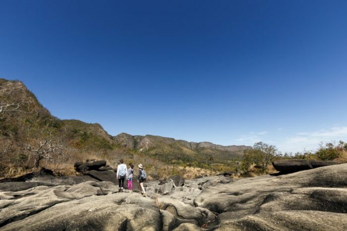 Uma família de 3 gerações caminhando sobre as rochas no Vale da Lua (Vale da Lua), Chapada dos Veadeiros (Planalto dos Veadeiros), Goiás, Brasil.